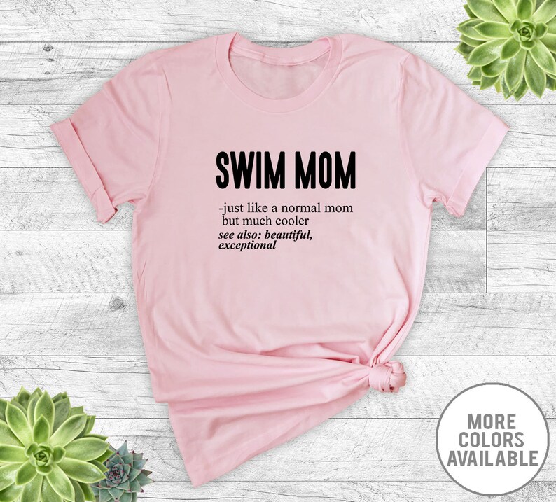 May include: Pink t-shirt with the text "SWIM MOM - just like a normal mom but much cooler see also: beautiful, exceptional" printed on it.