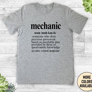 May include: A grey t-shirt with a humorous definition of the word "mechanic" printed on it. The definition reads: "noun/muh-kan-ik/ -someone who does precision guesswork based on unreliable data provided by those of questionable knowledge see also: wizard, magician"