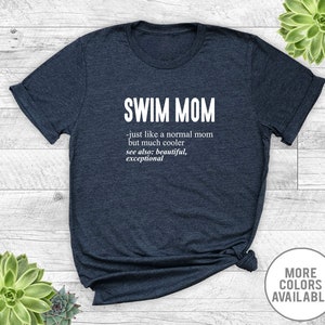 May include: Navy blue t-shirt with white text that reads "SWIM MOM - just like a normal mom but much cooler see also: beautiful, exceptional".