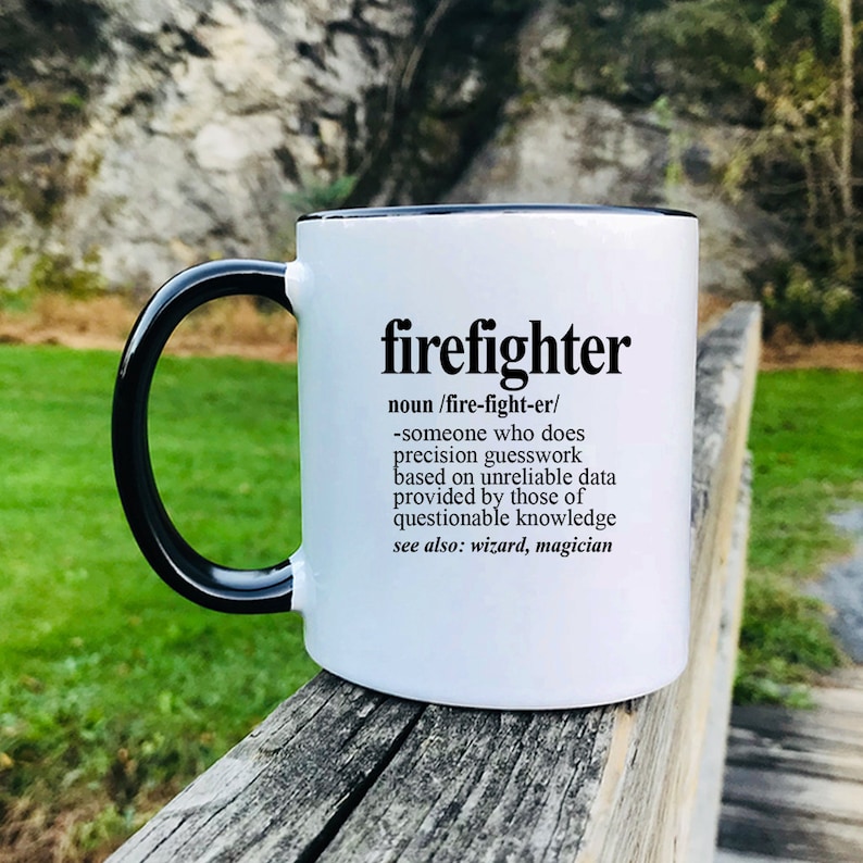 May include: White ceramic mug with a black rim and handle. The mug has a black graphic with the word "firefighter" and a definition of the word.