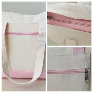 Pu&ograve; includere: Una borsa tote in tela con cerniera e pannello inferiore rosa chiaro. La borsa ha manici lunghi bianco sporco e un interno rosa abbinato. La borsa &egrave; realizzata in un tessuto robusto e strutturato.