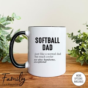 May include: White ceramic mug with a black handle and rim. The mug features the text "SOFTBALL DAD" in bold black letters, with additional text below. The mug has the "Family TeePrints" logo.