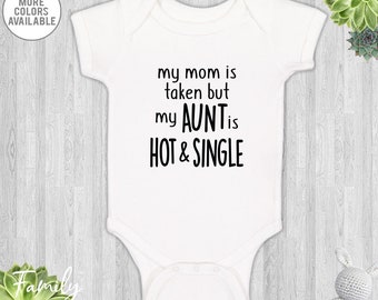 May include: White baby bodysuit with the text "my mom is taken but my AUNT is HOT & SINGLE" in black. The bodysuit has short sleeves and a snap closure. The words "MORE COLORS AVAILABLE" are in the upper left corner.