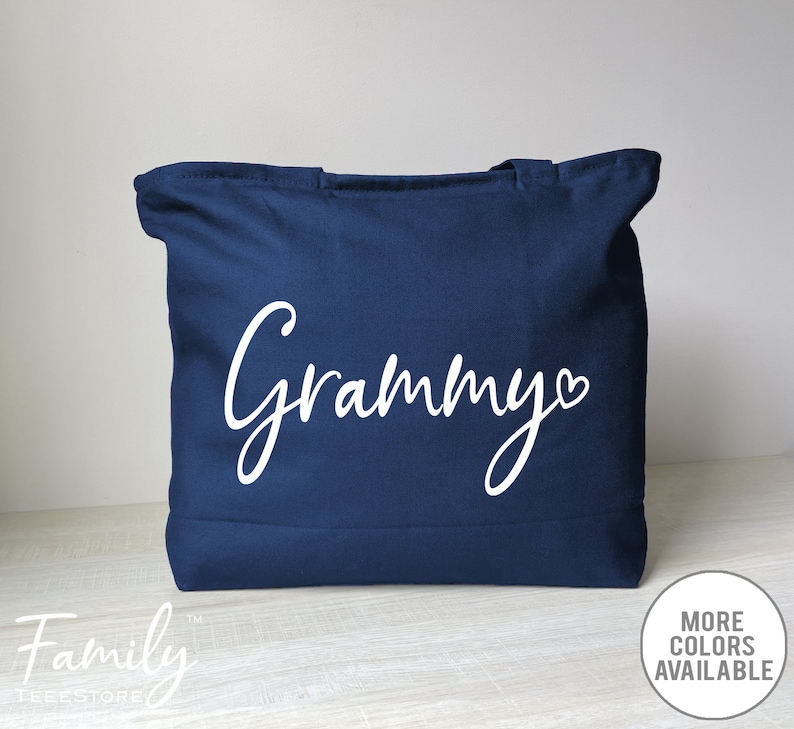May include: A navy blue tote bag with the word 'Grammy' in white cursive lettering with a small white heart after the 'y'.