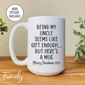 May include: White ceramic mug with black text that reads "Being my uncle seems like gift enough... but here's a mug. Merry Christmas 2024".
