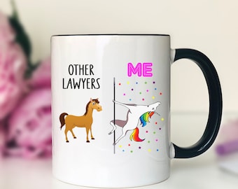 May include: White ceramic coffee mug with a black handle. The mug features a graphic of a horse on the left side and a unicorn on the right side. The text "OTHER LAWYERS" is printed above the horse and the text "ME" is printed above the unicorn.