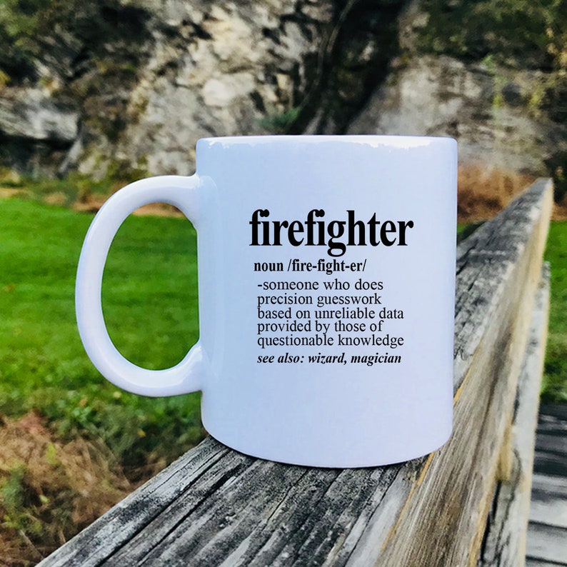 May include: White ceramic coffee mug with a black graphic that reads "firefighter" and a definition of the word. The definition reads: "noun /fire-fight-er/ -someone who does precision guesswork based on unreliable data provided by those of questionable knowledge see also: wizard, magician"