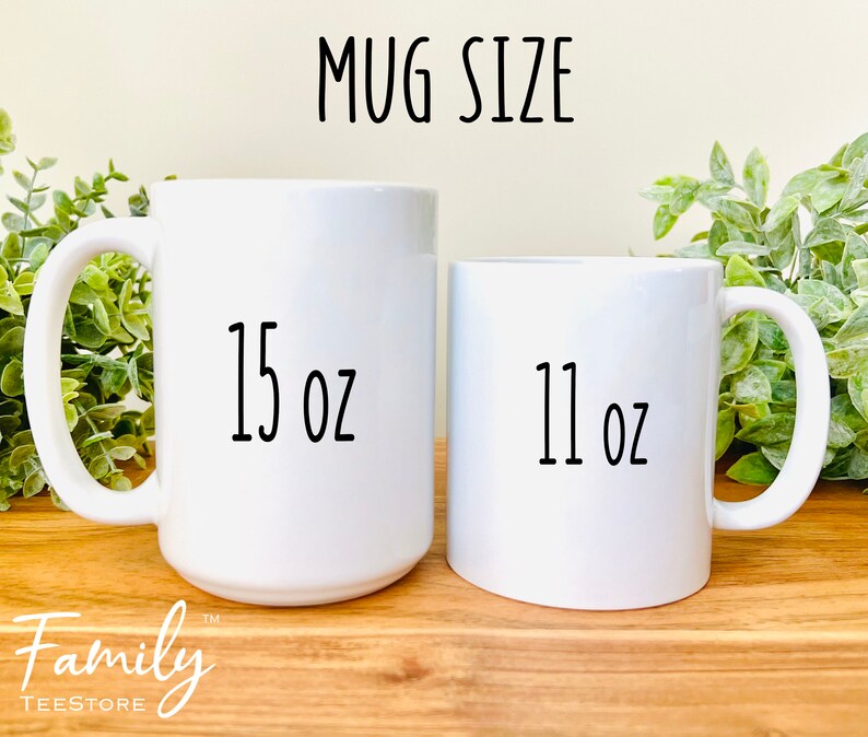 Pu&ograve; includere: Due tazze di ceramica bianca di diverse dimensioni. La tazza pi&ugrave; grande &egrave; etichettata "15 oz" e quella pi&ugrave; piccola "11 oz". Il testo "MUG SIZE" &egrave; sopra le tazze. Il logo Family TeeStore &egrave; in basso.