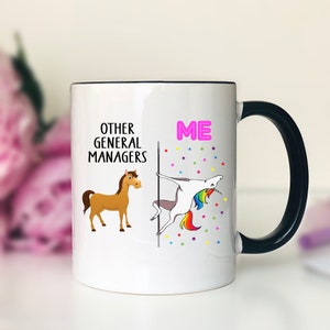 May include: White ceramic coffee mug with a black handle. The mug has a graphic of a horse on the left side and a unicorn on the right side. The text "Other General Managers" is printed above the horse and the text "ME" is printed above the unicorn.