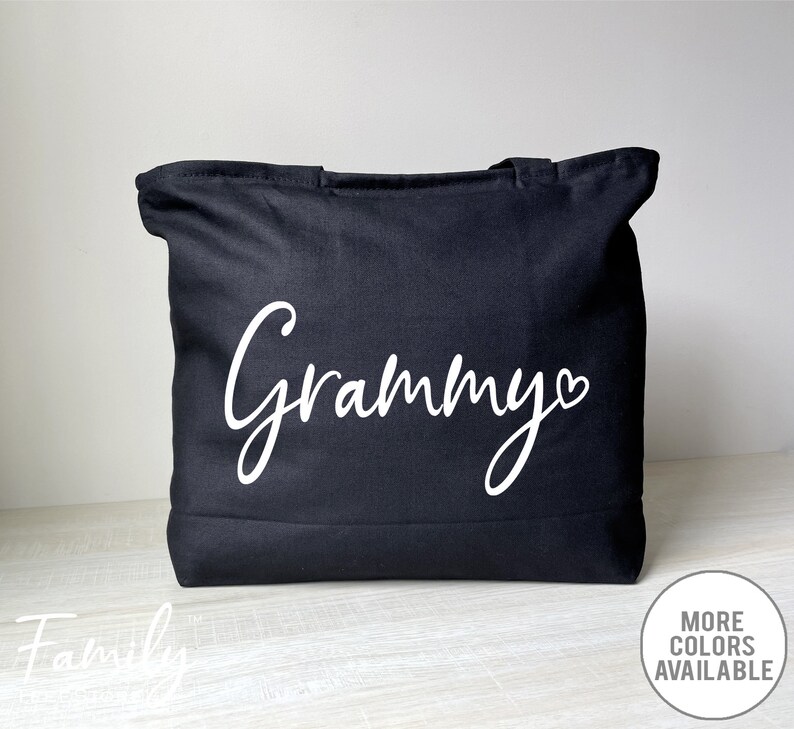 K&ouml;nnte beinhalten: Schwarze Stofftasche mit dem Wort "Grammy" in wei&szlig;er Kursivschrift mit einem kleinen Herz daneben.