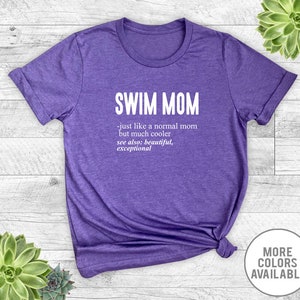 May include: Purple t-shirt with the text "SWIM MOM - just like a normal mom but much cooler see also: beautiful, exceptional" printed in white.