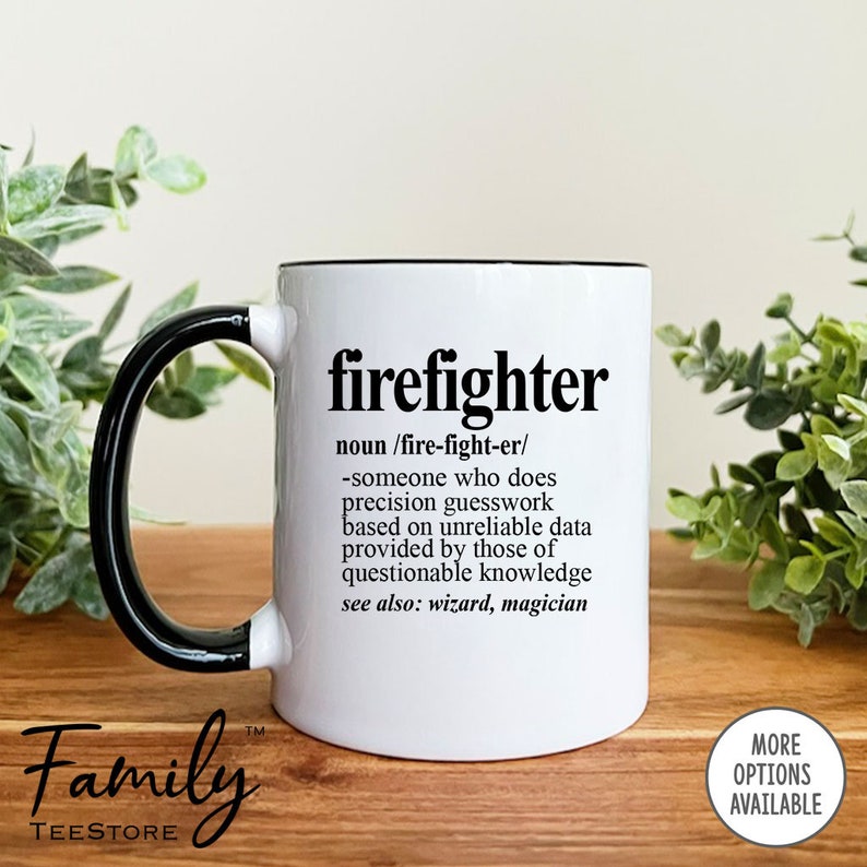 May include: White ceramic coffee mug with a black handle and rim. The mug has a black graphic that reads "firefighter" and a definition of the word. The text reads "noun /fire-fight-er/ -someone who does precision guesswork based on unreliable data provided by those of questionable knowledge see also: wizard, magician"