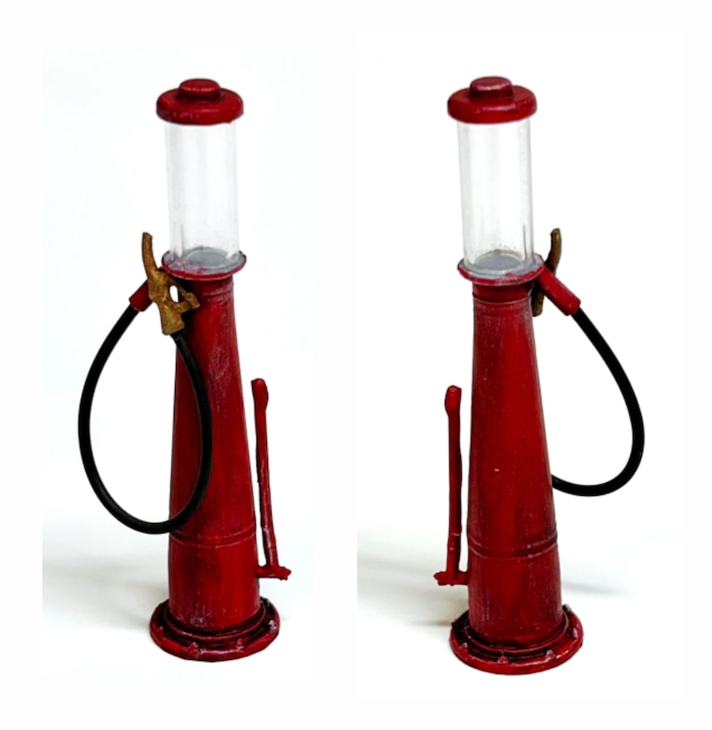 K&ouml;nnte beinhalten: Zwei Miniatur-Zapfs&auml;ulen in Rot mit einem Used-Look. Jede Pumpe hat einen transparenten Glaszylinder, einen schwarzen Schlauch und eine Messingd&uuml;se. Die Pumpen stehen vor wei&szlig;em Hintergrund.