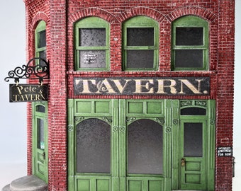 May include: A miniature brick building with a green facade and the word "TAVERN" above the entrance. The building has arched windows and a sign that reads "Pete's TAVERN". The building has a sign that says "UNFINISHED APARTMENT FOR RENT".