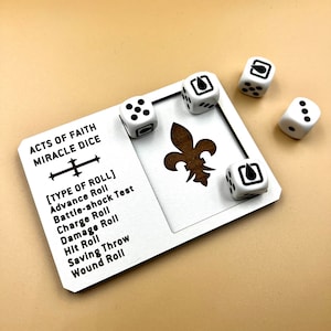 May include: White dice with black markings on a white wooden board with the text "ACTS OF FAITH MIRACLE DICE [TYPE OF ROLL] Advance Roll Battle-shock Test Charge Roll Damage Roll Hit Roll Saving Throw Wound Roll".