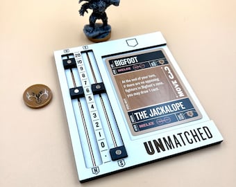Puede incluir: Un tablero de juego blanco con controles deslizantes negros y la palabra "UNMATCHED". Hay una carta y una miniatura de Bigfoot, junto con una ficha marrón. El tablero tiene un rastreador de salud y el texto "The Jackalope".