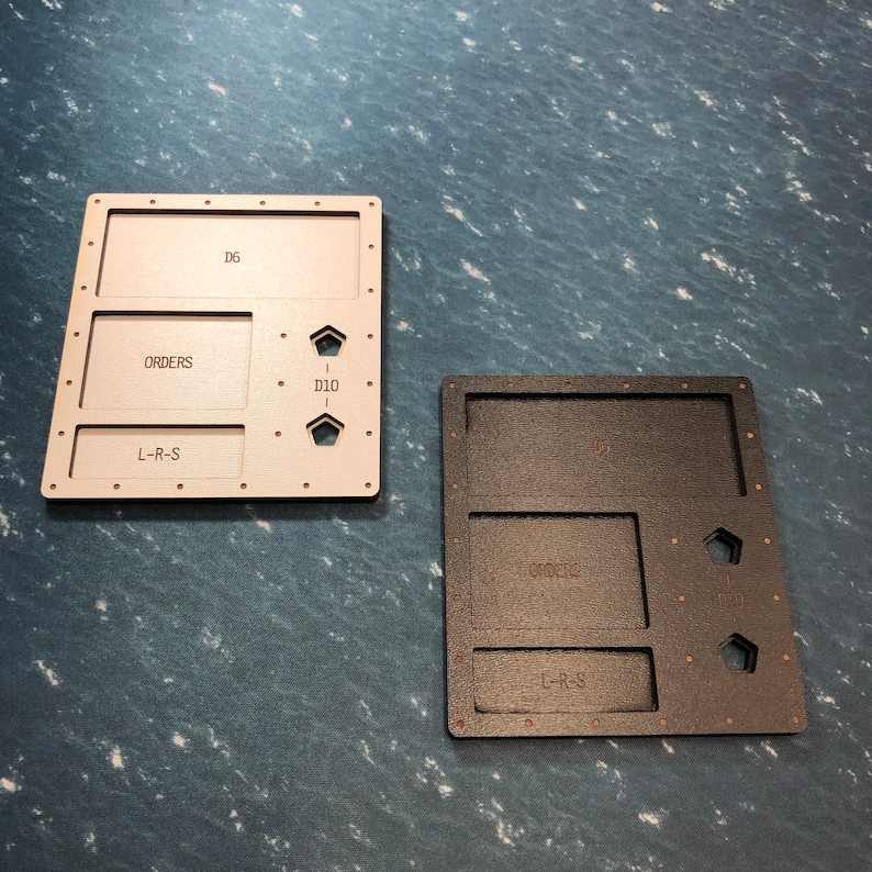 May include: Two wooden game trays, one in beige and one in black, with compartments labelled "Orders", "L-R-S", and "D10".