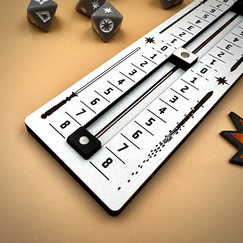 May include: A white wooden board with two rows of numbers from 0 to 8. The numbers are printed in black. There are two black sliders on the board. The board is used for a game.