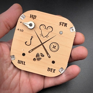 May include: Wooden character sheet with a mouse illustration and a needle and thread design. The sheet has dials for HP, STR, DEX, and WIL.