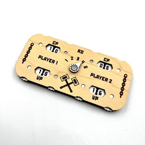 May include: A wooden game tracker with two player sections, each with a score dial, a "CP" score, and a "VP" score. The tracker also has a central dial with numbers 1 through 5, and a symbol of two crossed hammers.