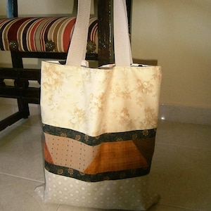 Peut inclure: Un sac cabas beige à motif floral, une bande à motif brun et vert et un fond à pois blancs.