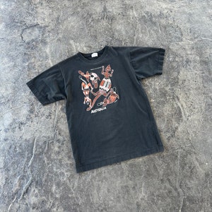 May include: Black t-shirt with a graphic print of stylized figures and the word "AUSTRALIA".