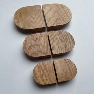 Può includere: Sei sottobicchieri in legno, ciascuno composto da due pezzi a forma di semicerchio. I sottobicchieri sono realizzati in legno chiaro con motivi di venature visibili. I sottobicchieri sono disposti su una superficie bianca.