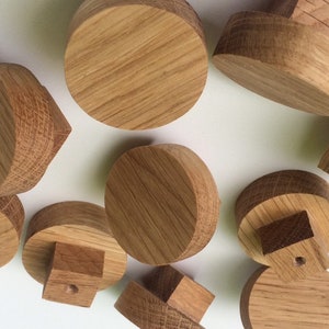 Puede incluir: Una colecci&oacute;n de componentes de madera sin terminar, probablemente para un proyecto de manualidades. Las piezas tienen varias formas, incluyendo cilindros y bloques, todas con un acabado de veta de madera natural. La disposici&oacute;n sugiere un tema de bricolaje o carpinter&iacute;a.