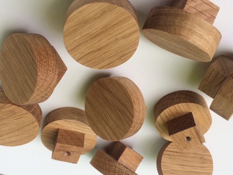 Puede incluir: Una colecci&oacute;n de componentes de madera sin terminar, probablemente para un proyecto de manualidades. Las piezas tienen varias formas, incluyendo cilindros y bloques, todas con un acabado de veta de madera natural. La disposici&oacute;n sugiere un tema de bricolaje o carpinter&iacute;a.