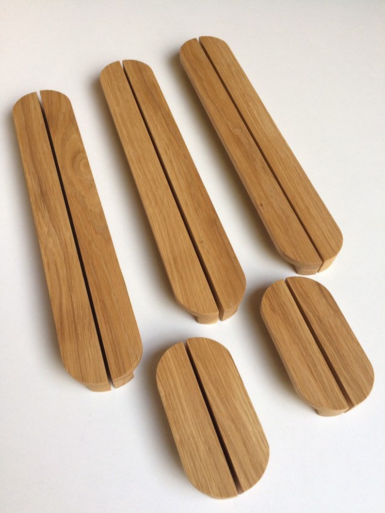 Puede incluir: Un conjunto de cinco soportes de tel&eacute;fono de madera clara. Cada soporte tiene una ranura central para sostener un tel&eacute;fono. Los soportes son de forma ovalada con extremos redondeados, ideales para escritorio.