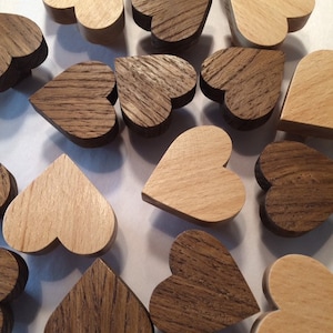 Peut inclure: Diverses découpes en forme de cœur en bois, dans des tons de marron et de beige. Les cœurs en bois présentent des motifs de grain visibles. Certains sont clairs, d'autres foncés. Les cœurs sont dispersés sur une surface blanche.