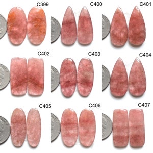 Puede incluir: Colección de nueve pares de piedras preciosas pulidas, de color rosa-rojo, en varias formas, incluyendo ovaladas, de lágrima y rectangulares. Cada par se muestra junto a una moneda para comparar el tamaño. Las piedras tienen un aspecto translúcido.