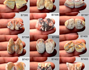 May include: Twelve pairs of agate cabochons, each pair is a matching set. The cabochons are various shapes and sizes, with a variety of colors and patterns, including brown, red, white, and yellow. The cabochons are arranged in a grid pattern on a white background.