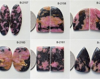 Puede incluir: Seis pares de piedras preciosas cabujón de color rosa y negro, cada par etiquetado con un código único, del B-2157 al B-2162. Las piedras preciosas se muestran junto a una moneda de veinticinco centavos de dólar estadounidense para comparar el tamaño.