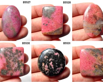 May include: Six different pink and black rhodochrosite cabochons, each with a unique pattern and shape. The cabochons are oval, rectangular, and round.