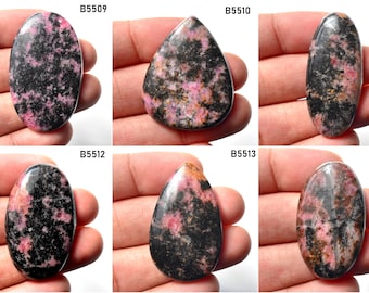 May include: Six cabochon cut gemstones with a pink and black pattern. The stones are oval and teardrop shaped. The stones are labeled B5509, B5510, B5511, B5512, B5513, and B5514.