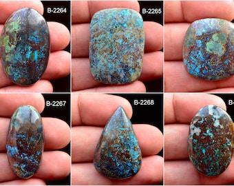 May include: Six cabochon cut chrysocolla stones in various shapes and sizes. The stones are a mix of blue, green, and brown colors with a mottled pattern.
