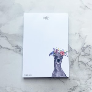May include: A white notepad with the word "NOTES" at the top. The bottom right corner features a watercolour illustration of a greyhound wearing a floral crown. The notepad is labelled "PIPA & PAPER" at the bottom left.