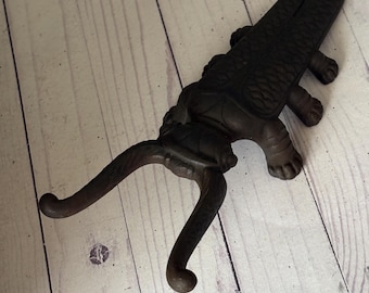 Antique cast iron Boot Jack shaped like a Beetle. Bottom says:Daniel. Functional.