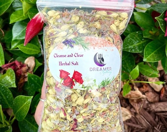 May include: A clear plastic bag filled with a blend of dried herbs, flowers, and salt. The bag is labeled "Cleanse and Clear Herbal Salt" and "DREAMER Apothecary".