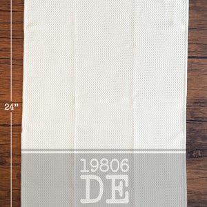 Puede incluir: Toalla de cocina de tejido de gofre blanco con una franja gris y el texto "19806 DE" en blanco. La toalla mide 40,6 cm por 61 cm.