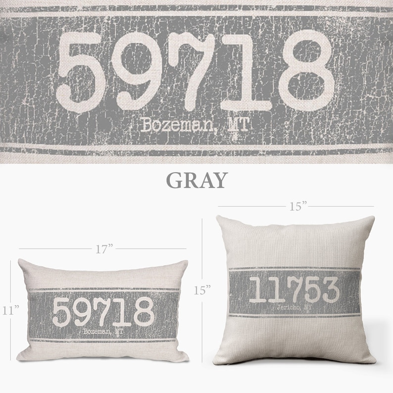 Op de afbeelding: Een rechthoekig kussen in grijs en wit met de tekst "59718 Bozeman, MT" erop gedrukt. Het kussen is 17 inch breed en 15 inch lang.