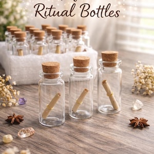 May include: Clear glass mini ritual bottles with cork stoppers. Each bottle contains a rolled scroll and a gold-colored ring. The bottles are arranged on a wooden surface, with the text "Mini Ritual Bottles" in a script font.