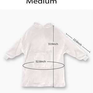 Może przedstawiać: Biały koc z kapturem i rękawami, o wymiarach 33,9 cala wysokości, 22,8 cala szerokości i 52,8 cala obwodu. Koc ma kieszeń z przodu.