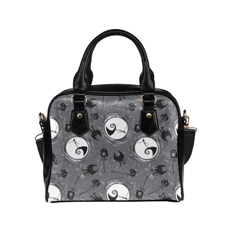 K&ouml;nnte beinhalten: Schwarze Handtasche mit einem grau-wei&szlig;en Muster, das eine Figur aus Nightmare Before Christmas zeigt. Das Muster enth&auml;lt auch Flederm&auml;use, K&uuml;rbisse und einen Mond.