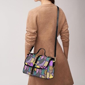 May include: A colorful crossbody bag with a patchwork design. The bag features a black strap and handle, with a flap closure. The patchwork design includes various shapes and colors, such as purple, yellow, and teal.