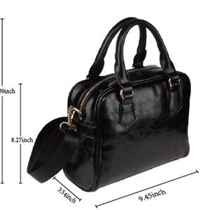 K&ouml;nnte beinhalten: Schwarze Ledertasche mit Henkel und verstellbarem Schultergurt. Die Tasche ist 34 cm hoch, 24 cm breit und 21 cm tief.