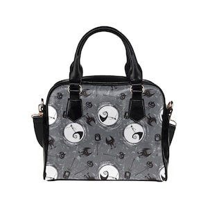 K&ouml;nnte beinhalten: Eine schwarze Handtasche mit einem grau-wei&szlig;en Muster, das einen Charakter aus Nightmare Before Christmas zeigt. Das Muster enth&auml;lt einen Mond, einen K&uuml;rbis und eine Fledermaus.