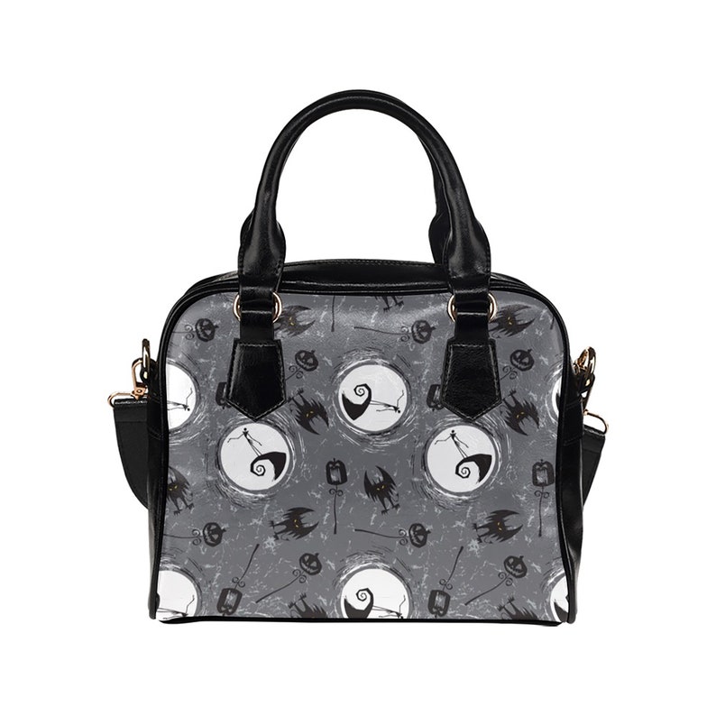 K&ouml;nnte beinhalten: Eine schwarze Handtasche mit einem grau-wei&szlig;en Muster, das einen Charakter aus Nightmare Before Christmas zeigt. Das Muster enth&auml;lt einen Mond, einen K&uuml;rbis und eine Fledermaus.