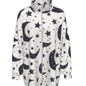 Puede incluir: Chaqueta blanca con cremallera con un diseño celestial de lunas crecientes, estrellas y puntos de color azul oscuro. La chaqueta tiene cuello alto y mangas largas. La cremallera es de color gris claro.